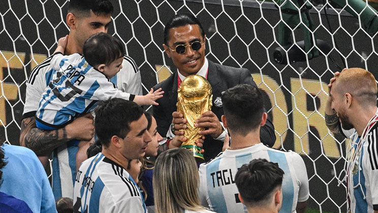 Nusret Gokce memegang trofi Piala Dunia bersama pemain Argentina